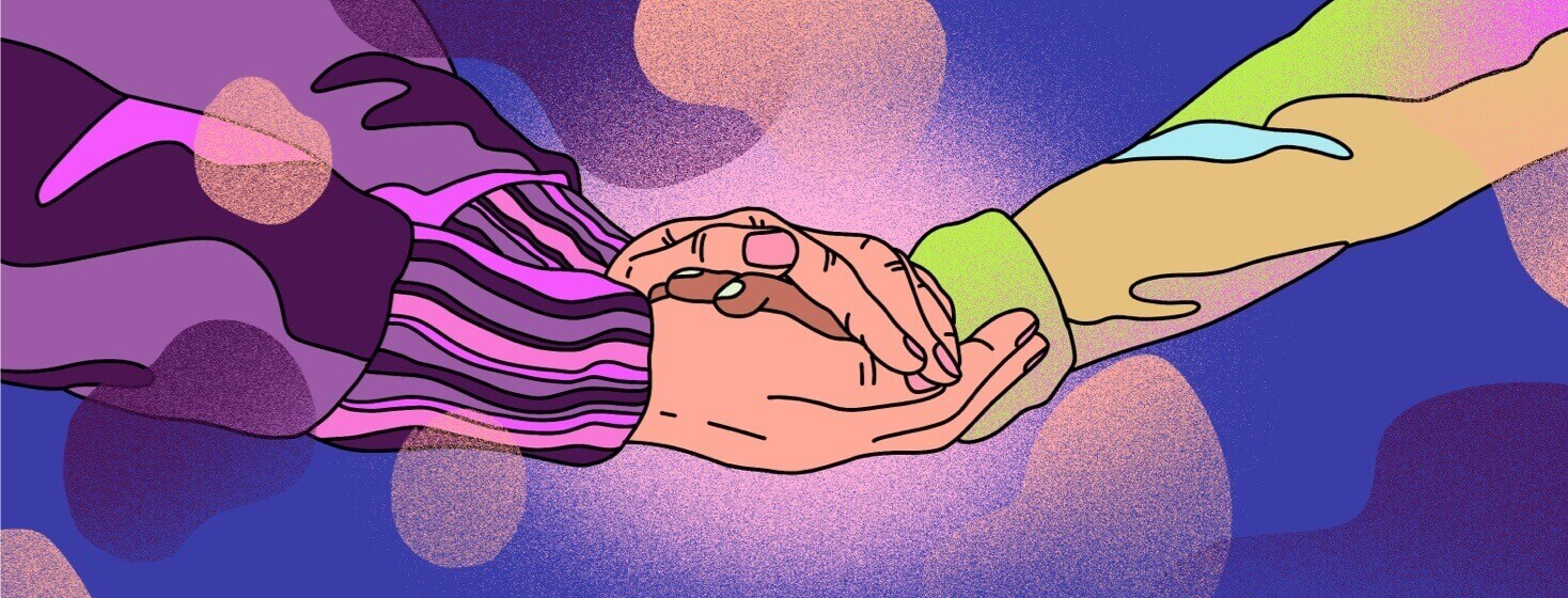 One person's hands reach out to hold another's in a gesture of comfort
